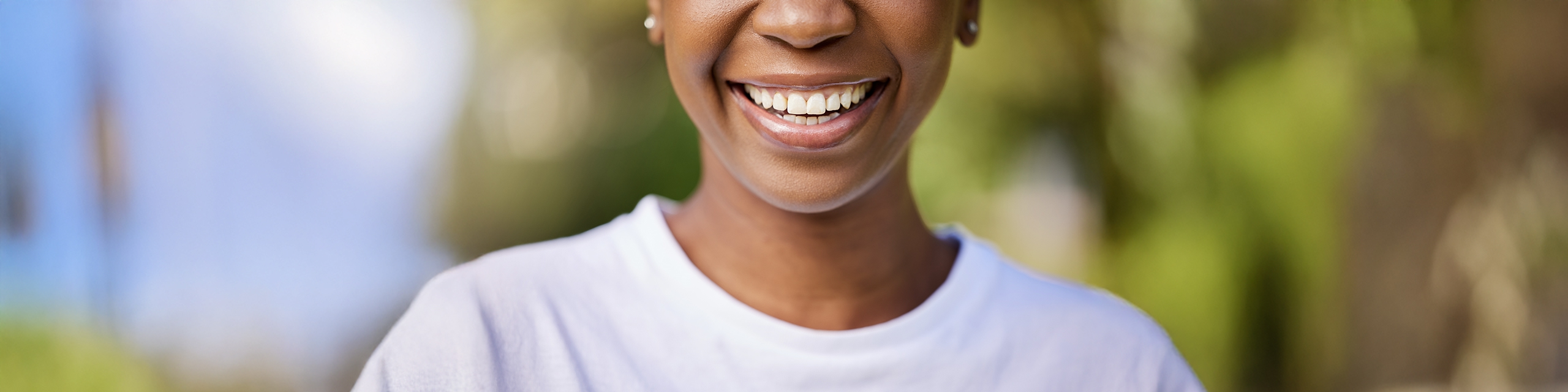 Close-up of a smiling woman outdoors representing scent-triggered nostalgia.